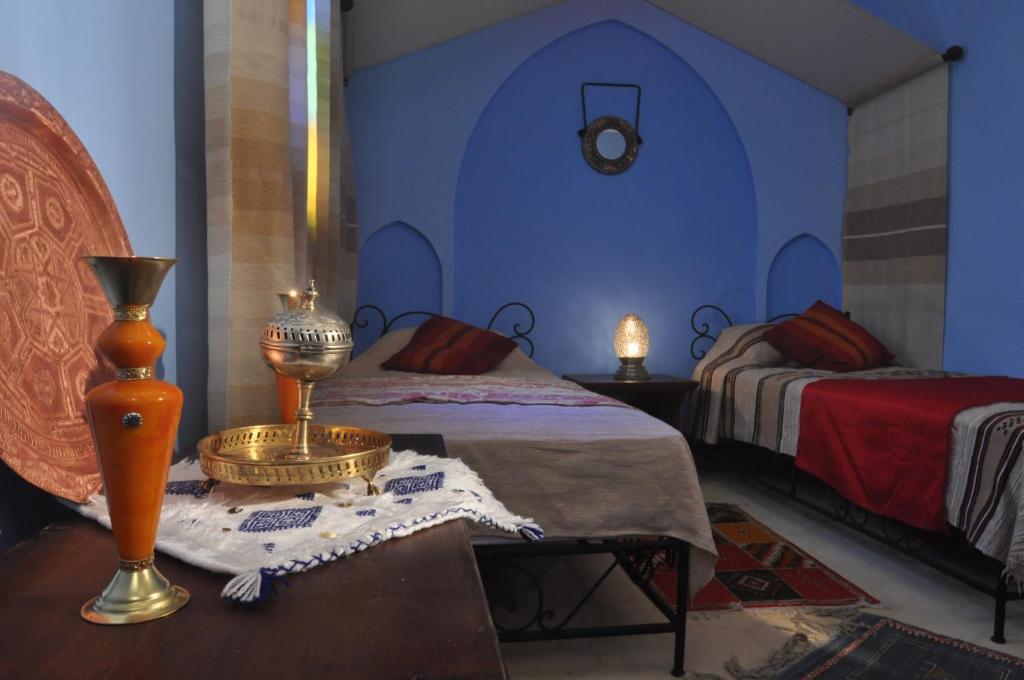 une chambre avec deux lits et une table avec une lampe dans l'établissement Riad La Famille, à Marrakech