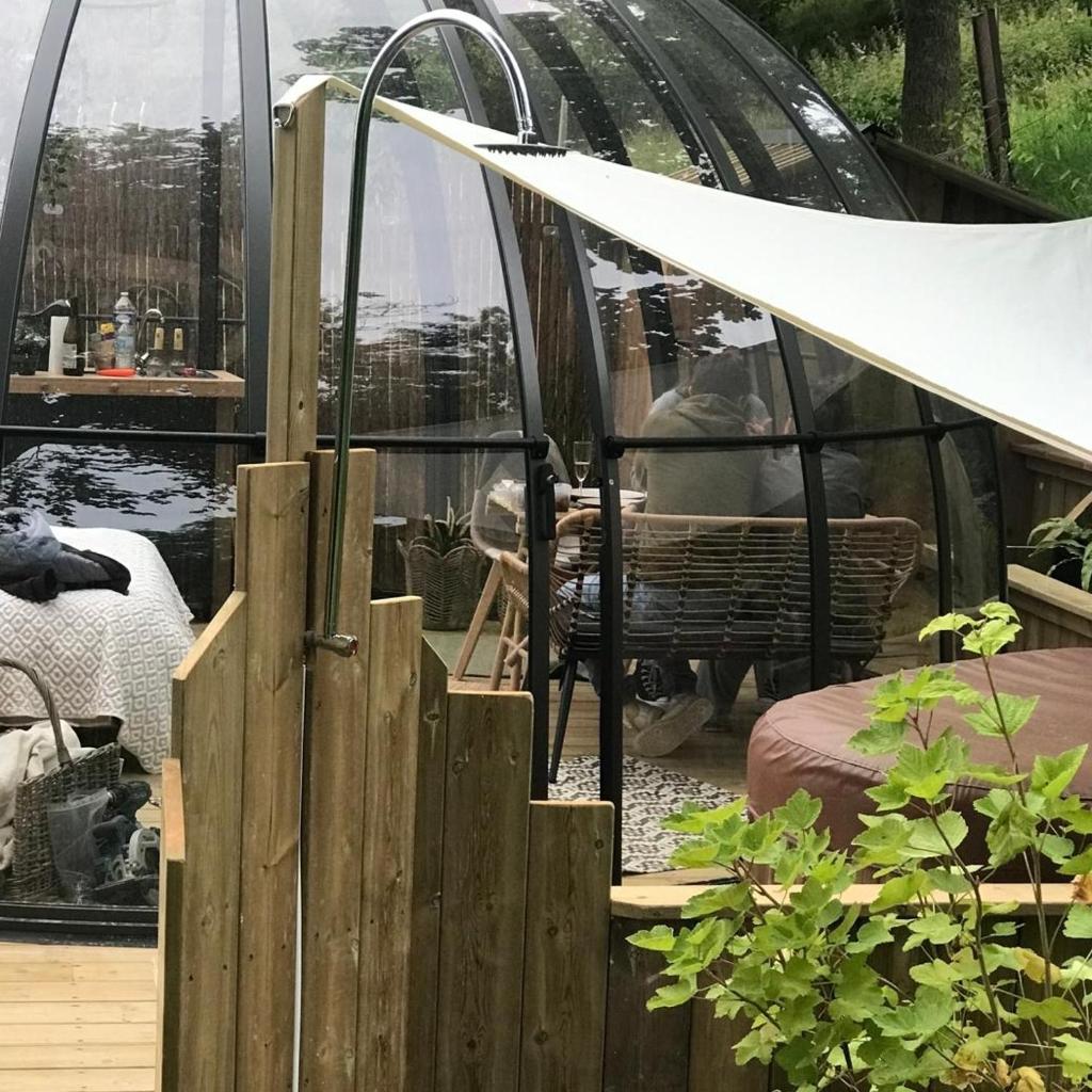 un igloo en verre avec une clôture devant lui dans l'établissement Dôme de la bergerie, à Saint-Valery-en-Caux