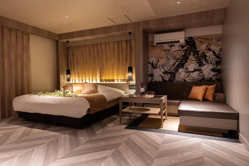 une chambre d'hôtel avec un lit et un canapé dans l'établissement hotel AYA Adult Only, à Shijonawate