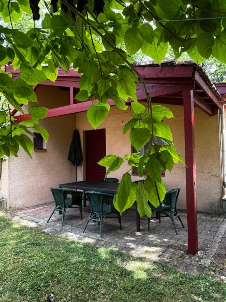 une table et des chaises devant une maison dans l'établissement Gîte 6 personnes avec piscine, à Agnac