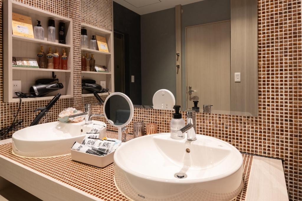 une salle de bain avec deux lavabos et un miroir dans l'établissement hotel AYA Adult Only, à Shijonawate