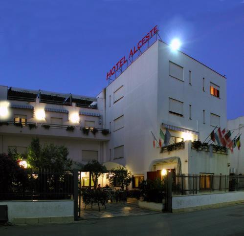 un bâtiment blanc avec une pancarte sur le côté dans l'établissement Hotel Alceste, à Marinella di Selinunte
