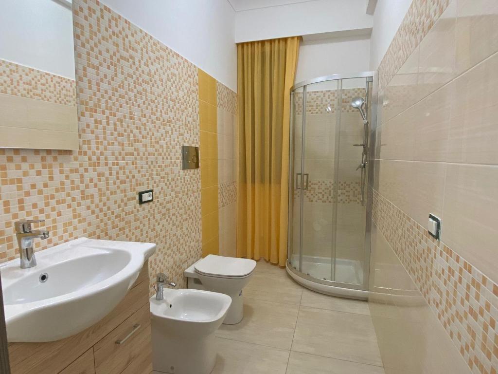 une salle de bain avec un lavabo, des toilettes et une douche dans l'établissement Giotera Village, à Sciacca