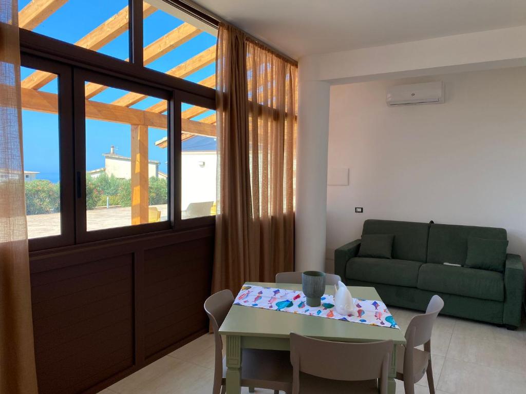 - un salon avec une table et un canapé vert dans l'établissement Giotera Village, à Sciacca