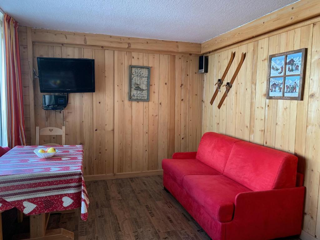 un salon avec un canapé rouge et une télévision dans l'établissement Studio 20 Les Grandes Platières, à Tignes