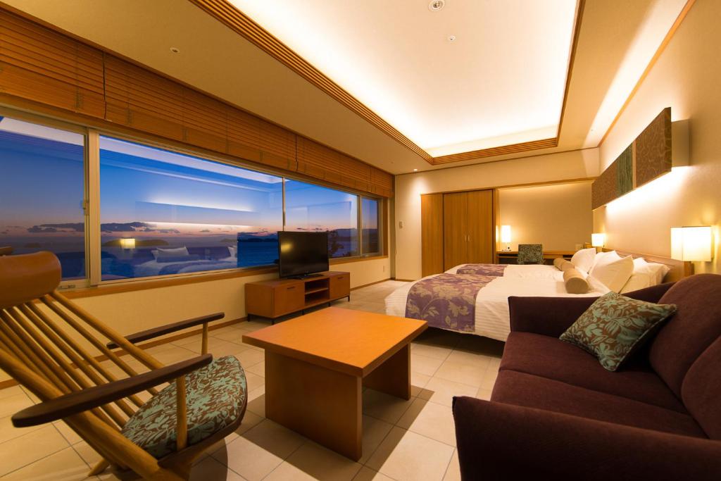 une chambre d'hôtel avec un lit et une grande fenêtre dans l'établissement Hotel Meizanso, à Gamagori