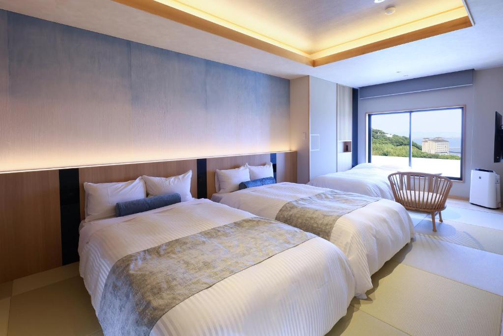 une chambre d'hôtel avec deux lits et une fenêtre dans l'établissement Hotel Meizanso, à Gamagori