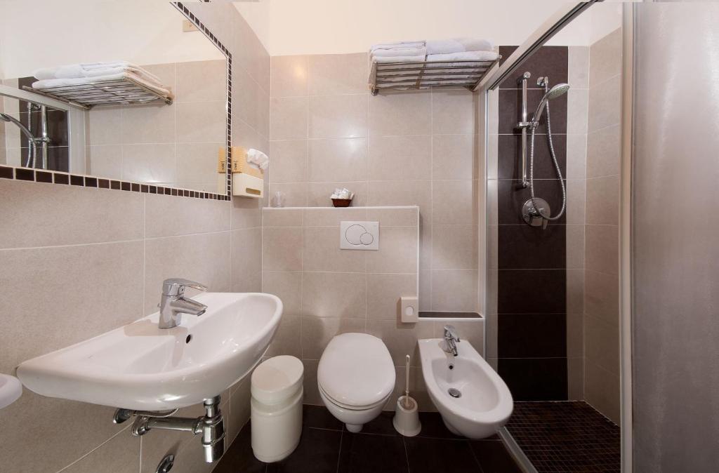 une salle de bain avec un lavabo, des toilettes et un miroir dans l'établissement Hotel Ricci, à Rimini