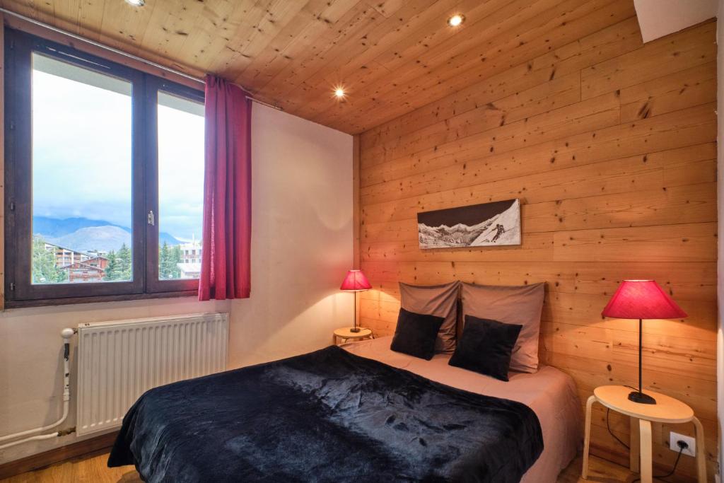 une chambre avec un lit dans un mur en bois dans l'établissement Lauvitel K5, à Les Deux Alpes