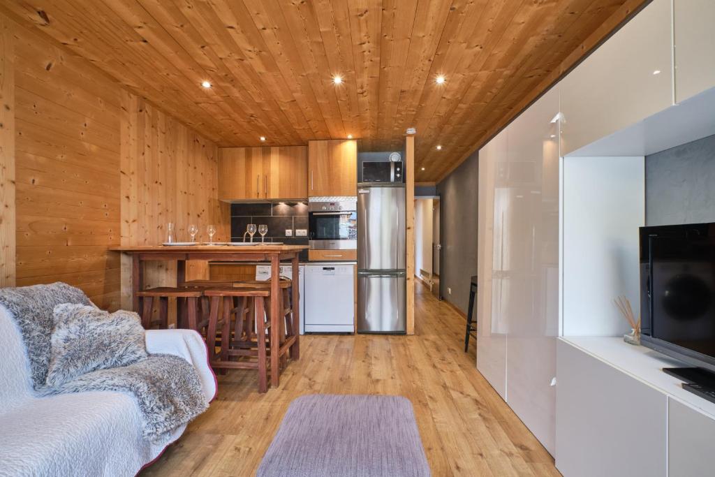 Il comprend une cuisine et un salon avec des murs en bois. dans l'établissement Lauvitel K5, à Les Deux Alpes 12 autres photos