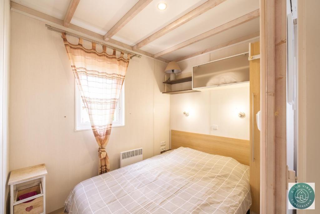 une petite chambre avec un lit et une fenêtre dans l'établissement Parc résidentiel les vignes, à Lit-et-Mixe