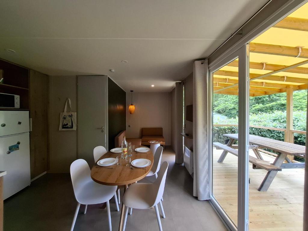 une cuisine et une salle à manger avec une table et des chaises en bois dans l'établissement Camping L'AMBOIS, à Mouilleron-le-Captif