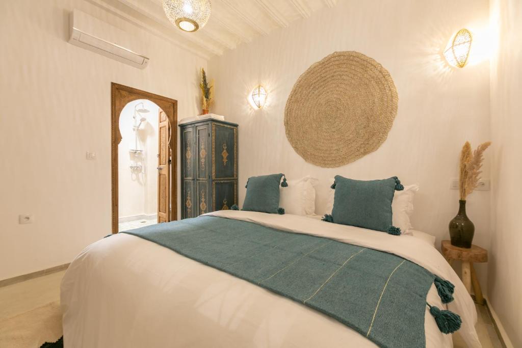 une chambre avec un grand lit avec des oreillers bleus dans l'établissement Riad Lamalika, à Marrakech 37 autres photos