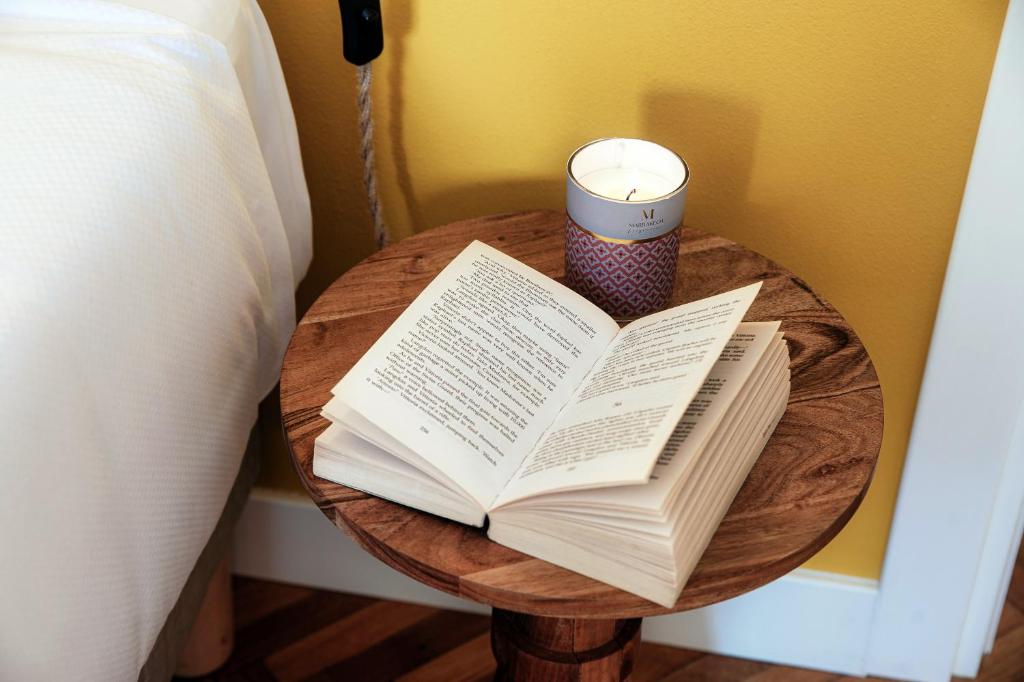 un livre ouvert sur une table à côté d'un lit dans l'établissement Villa Riva - by MyHomeInComo, à Lenno