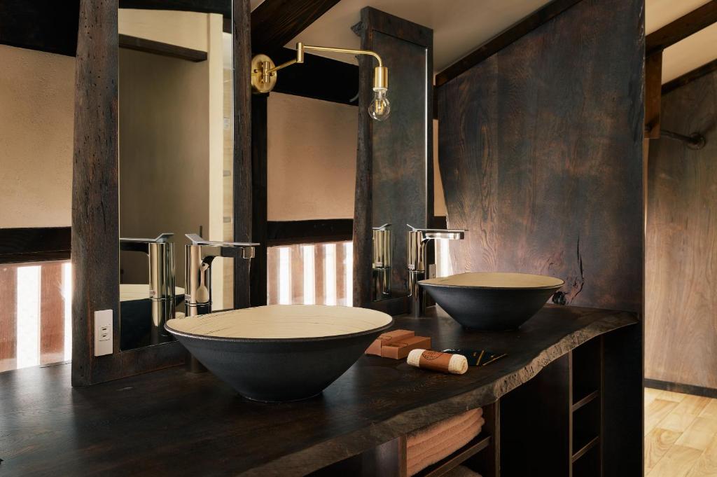 une salle de bain avec deux lavabos sur un comptoir dans l'établissement Onsen and Garden Nana, à Kanazawa
