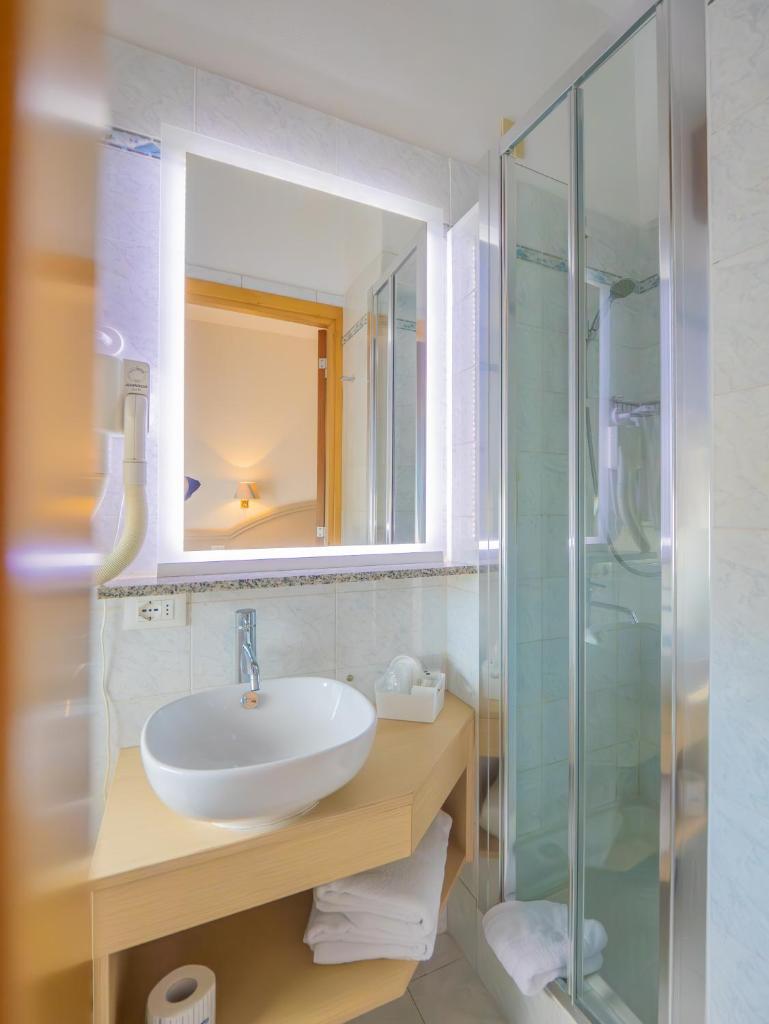 une salle de bain avec un lavabo et une douche en verre dans l'établissement Hotel Splendid, à Diano Marina