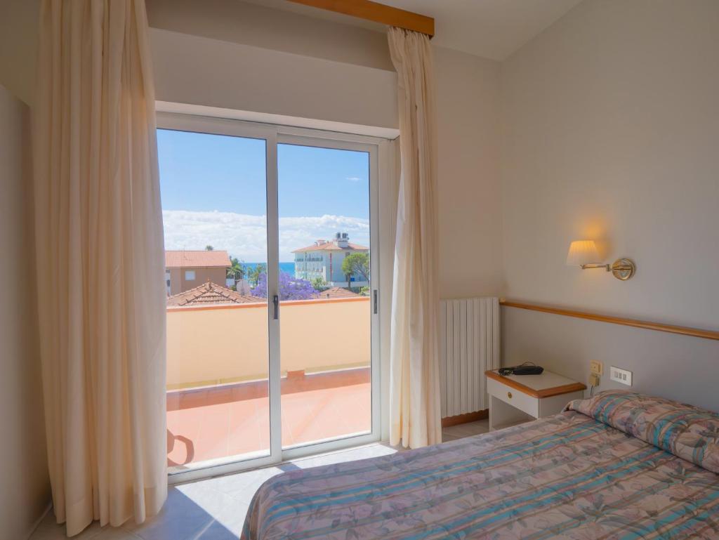 une chambre avec un lit et une grande fenêtre dans l'établissement Hotel Splendid, à Diano Marina