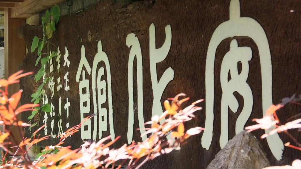un panneau sur un mur avec un peu d'écriture sur celui-ci dans l'établissement Andaikan, à Yamanouchi