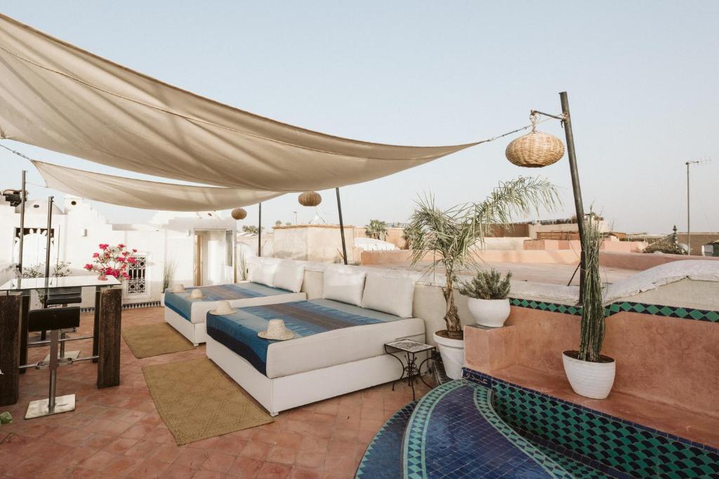 - un toit-terrasse avec des canapés et une table dans l'établissement Riad Dar Alhambra, à Marrakech