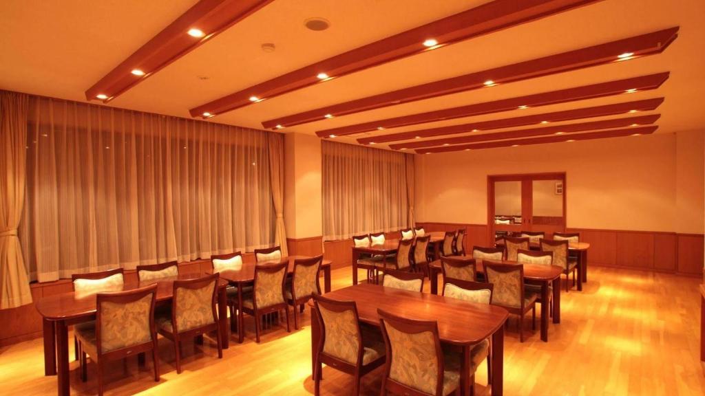 une salle à manger avec des tables et des chaises en bois dans l'établissement Resort Project Myoko Kogen Hot Spring, à Myōkō