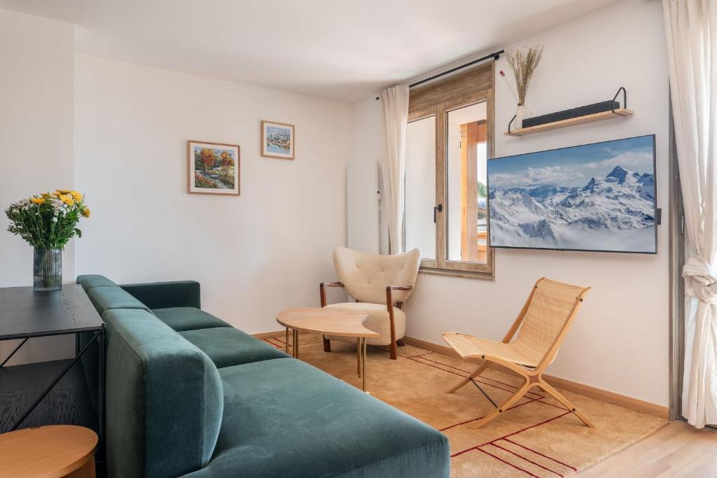 un salon avec un canapé, des chaises et une fenêtre dans l'établissement Apartment Bavella Alpe d'Huez - by EMERALD STAY, à Huez