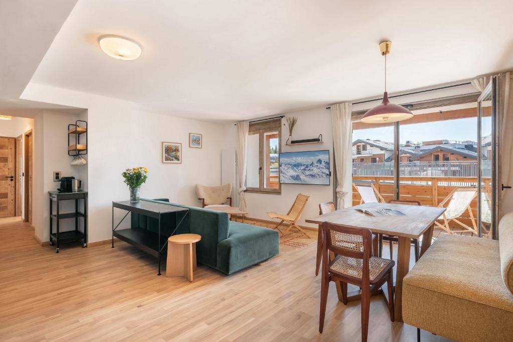 un salon avec un canapé vert et une table dans l'établissement Apartment Bavella Alpe d'Huez - by EMERALD STAY, à Huez