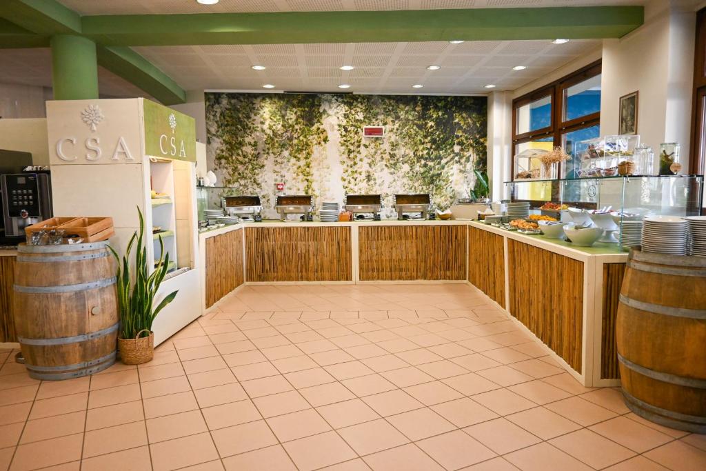 un restaurant avec un bar avec des tonneaux dans une salle dans l'établissement CSA Hotel Beach & Park, à Marina di Bibbona