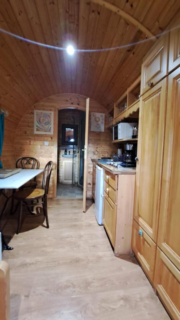 - une cuisine dans une cabane en rondins avec une table dans l'établissement Roulotte viticole, à Loulle