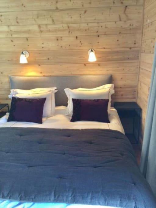 une chambre avec un grand lit avec deux oreillers dans l'établissement Lovely 4 bedroom apt ski-in ski-out with sauna, aux Houches
