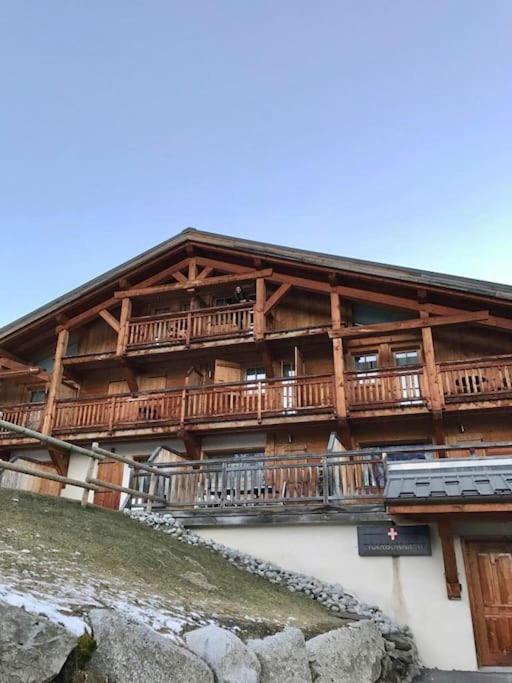 - un bâtiment avec des balcons en bois sur le côté dans l'établissement Lovely 4 bedroom apt ski-in ski-out with sauna, aux Houches