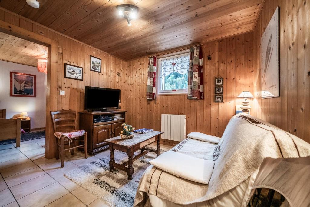 - un salon avec des boiseries et une télévision dans l'établissement Chalet Ermena, à Saint-Jean-dʼAulps