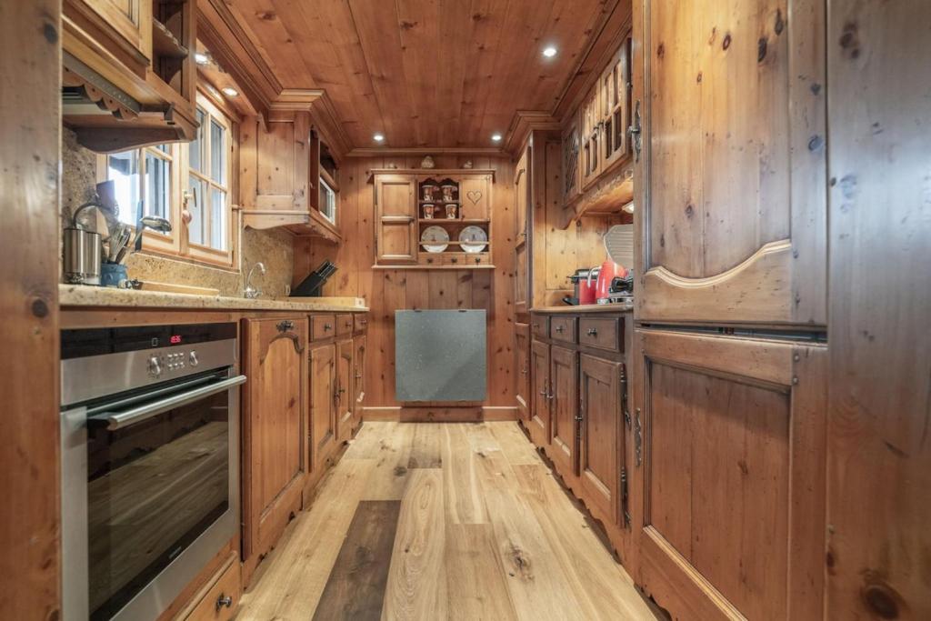 - une cuisine avec des placards en bois et du parquet dans l'établissement Chalet Joseph, à Courchevel 18 autres photos