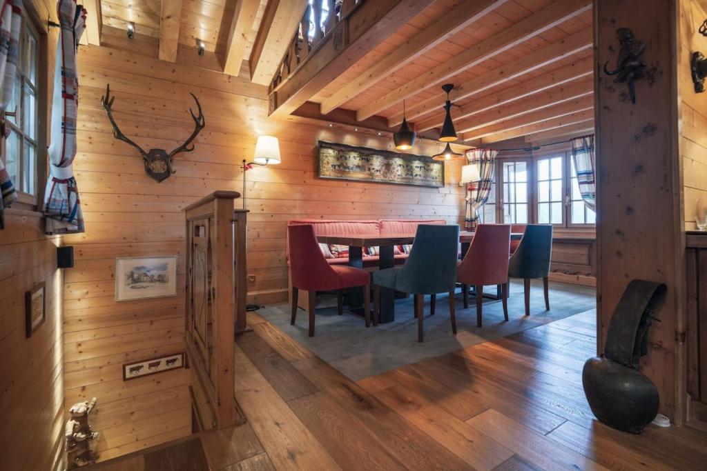 - une salle à manger avec des murs en bois, une table et des chaises dans l'établissement Chalet Joseph, à Courchevel