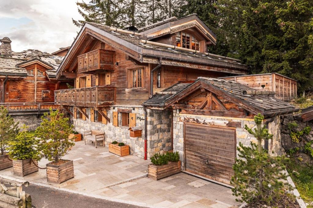une grande maison en bois avec un garage en face de celle-ci dans l'établissement Chalet Joseph, à Courchevel