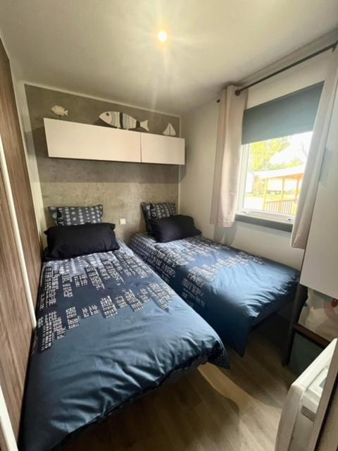 une chambre avec deux lits et une fenêtre dans l'établissement CHEZ Soso et Jean-Mi, à Lège-Cap-Ferret