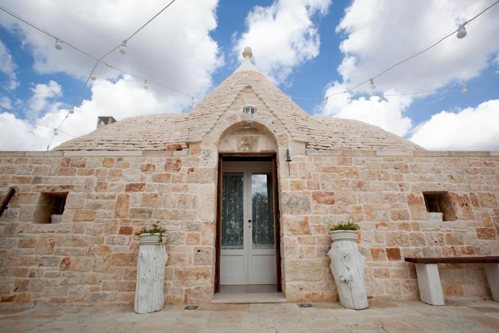- un bâtiment en briques avec une porte devant dans l'établissement Trullo Oasi Santo Stefano - private pool, à Castellana Grotte