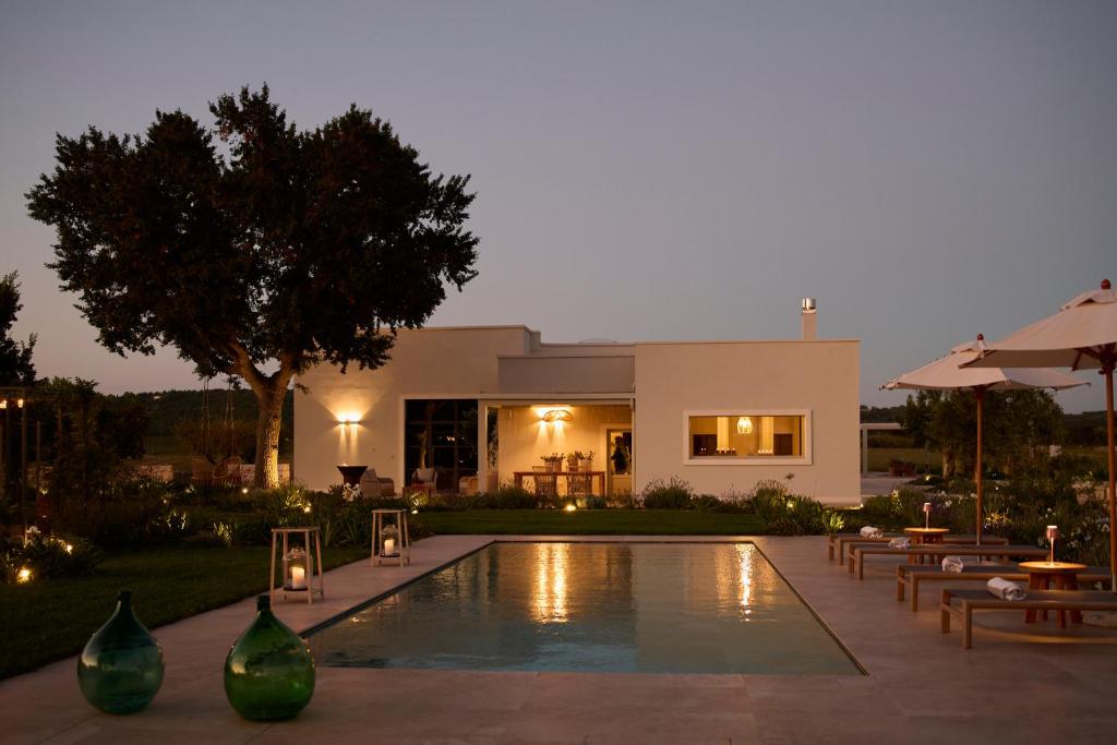 une villa avec piscine devant une maison dans l'établissement Tenuta Giotta, à Castellana Grotte