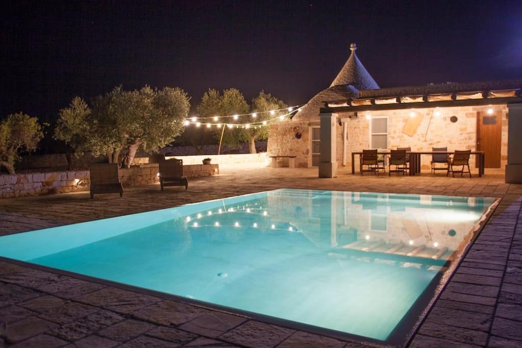 une piscine dans une cour la nuit dans l'établissement Trullo Oasi Santo Stefano - private pool, à Castellana Grotte