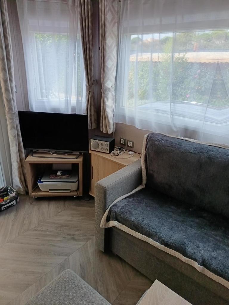 un salon avec un canapé et une télévision à écran plat dans l'établissement Le petit paradis, à Fréjus 7 autres photos