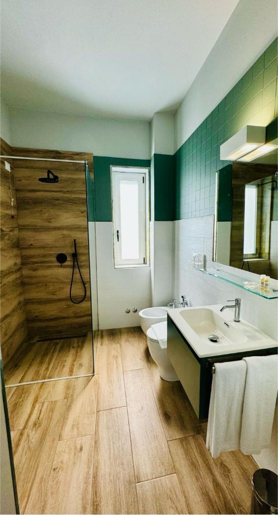 une salle de bain avec un lavabo, des toilettes et une douche dans l'établissement Hotel Lo Scoglio, à Porto Cesareo
