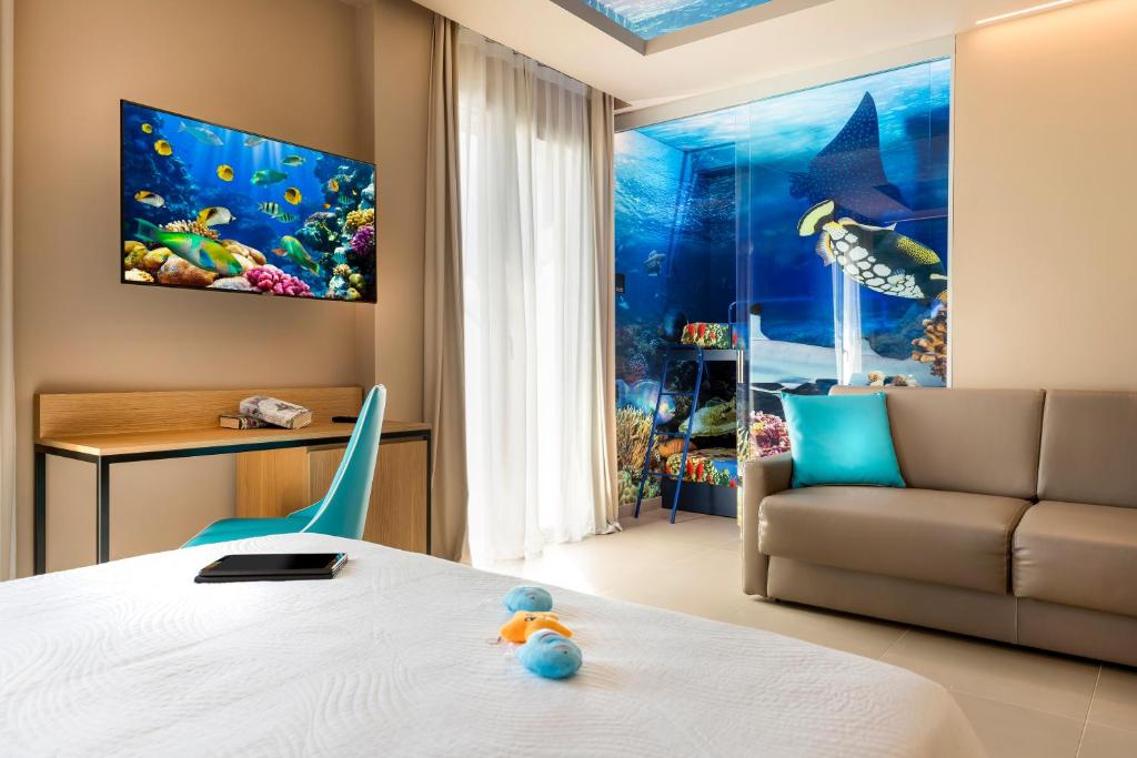 une chambre d'hôtel avec un lit et un canapé dans l'établissement Hotel Adlon - FRONTE MARE, à Riccione