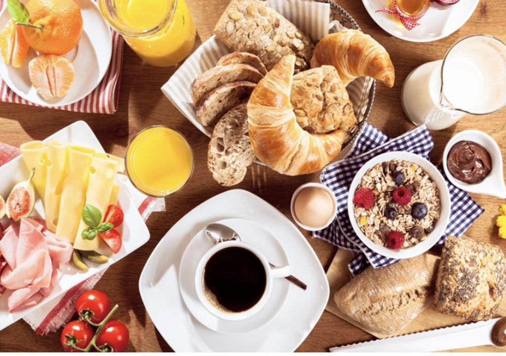 - une table remplie d'aliments pour le petit-déjeuner et de café sur une table dans l'établissement Apartment Bavella Alpe d'Huez - by EMERALD STAY, à Huez