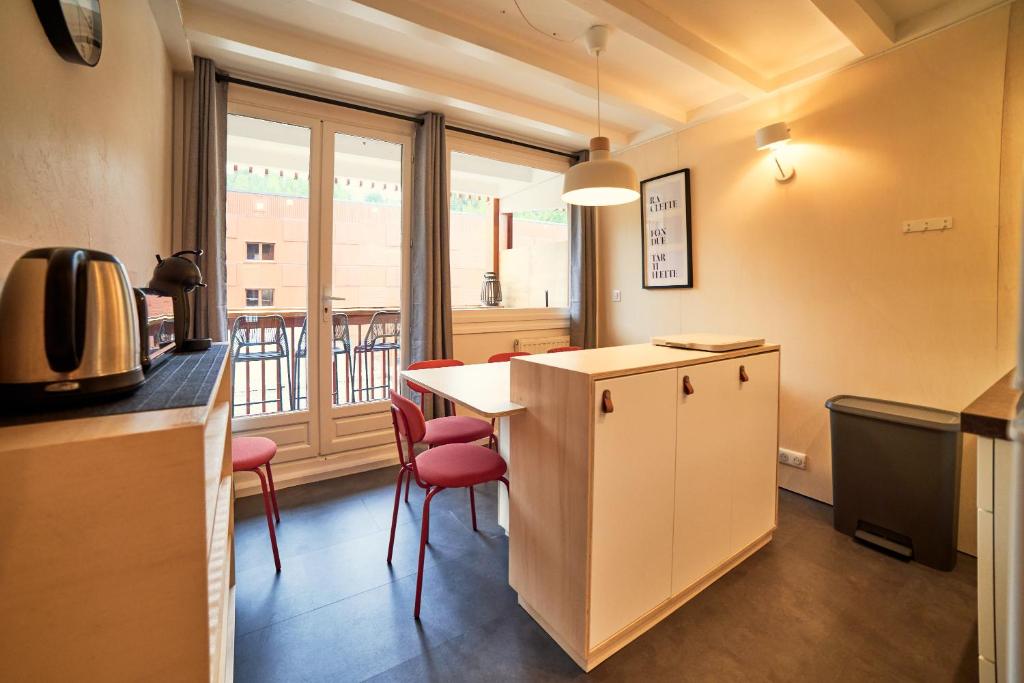 une cuisine avec un comptoir et une table avec des chaises dans l'établissement Appartement rénové au pied des pistes, à La Plagne 28 autres photos