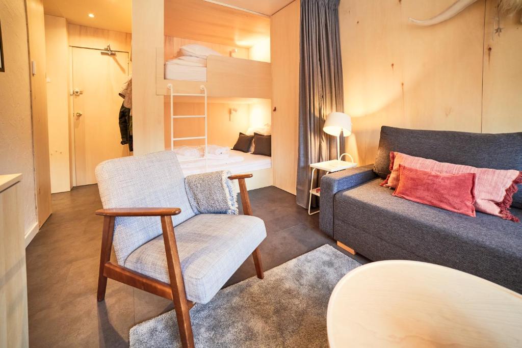 un salon avec un canapé et une chaise dans l'établissement Appartement rénové au pied des pistes, à La Plagne