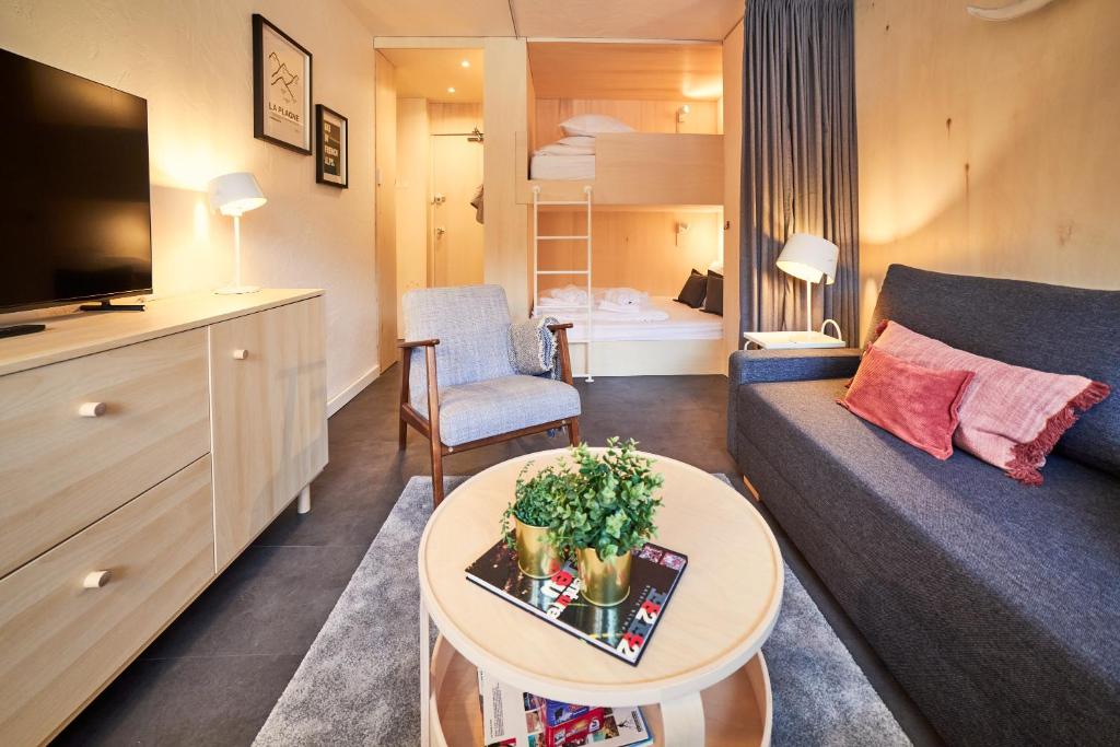 un petit salon avec un canapé et une table dans l'établissement Appartement rénové au pied des pistes, à La Plagne