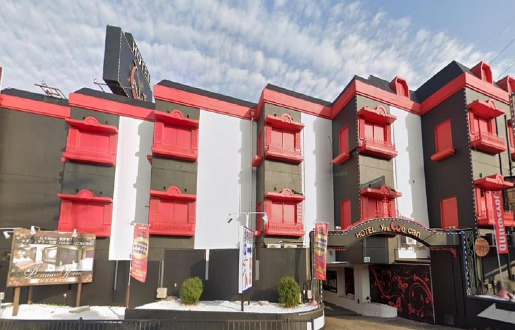 un bâtiment avec des volets rouges dans l'établissement 奈良生駒市 Yes We Can イエスウィキャン 生駒店ー大人専用ー, à Ikuma