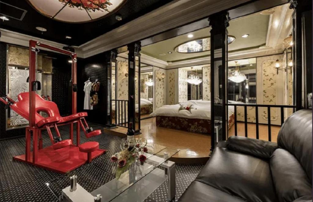 une chambre avec un canapé et une chambre avec un lit dans l'établissement 奈良生駒市 Yes We Can イエスウィキャン 生駒店ー大人専用ー, à Ikuma