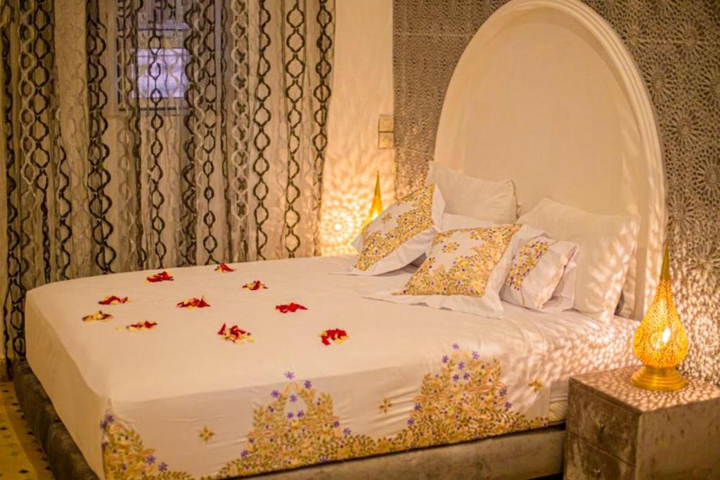 une chambre avec un lit blanc avec des fleurs dessus dans l'établissement Riad Rayhana, à Fès
