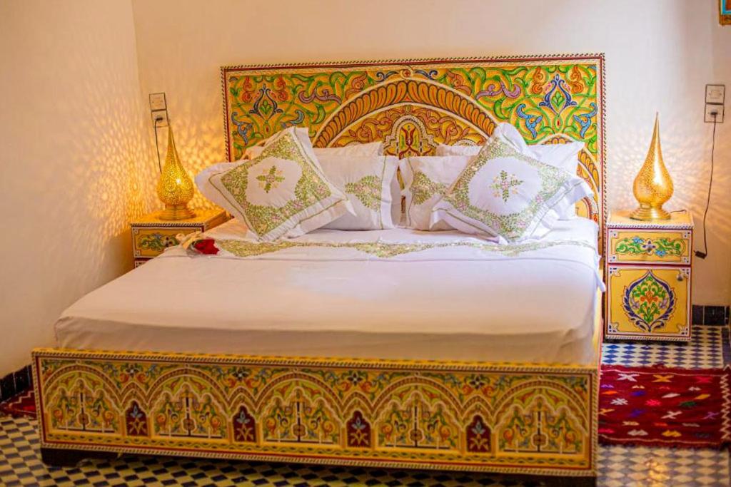 une chambre avec un grand lit avec des oreillers blancs dans l'établissement Riad Rayhana, à Fès