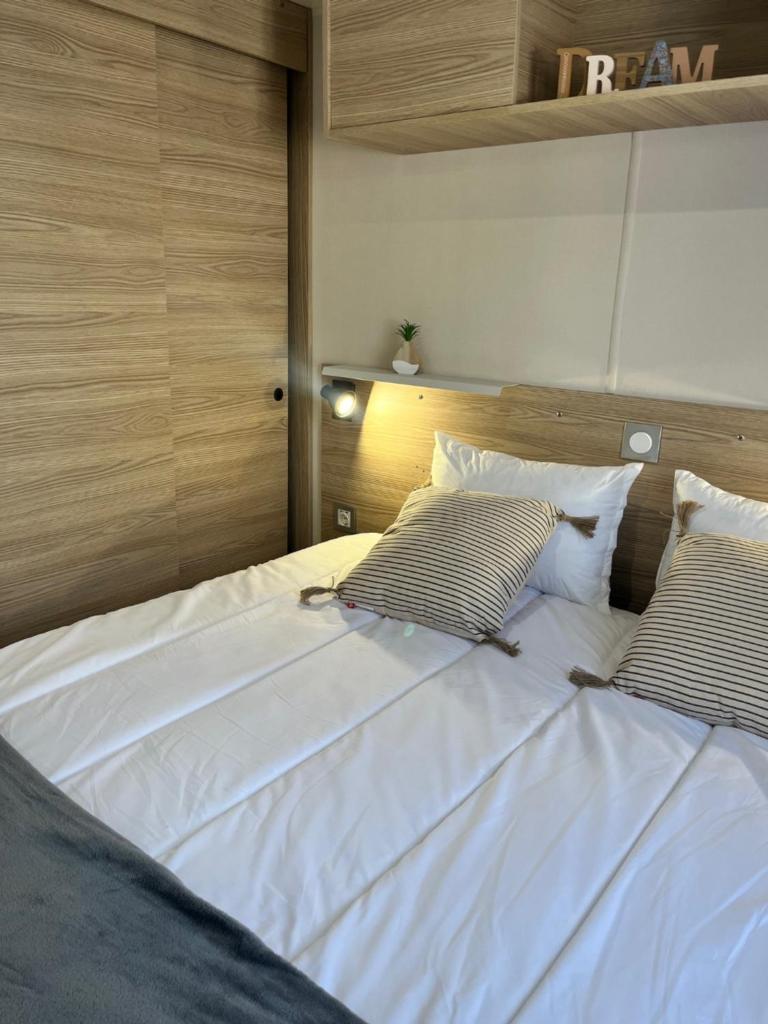 un grand lit blanc avec deux oreillers dessus dans l'établissement Mobil Home CasaLuca 3 chambres 2 Salles d'eau, à Canet 37 autres photos